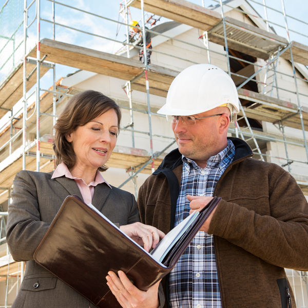 Eine Frau zeigt einem Handwerker Dokumente