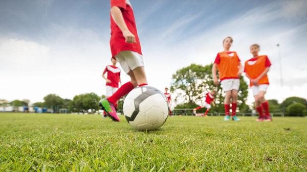 Kinder spielen zusammen Fußball.