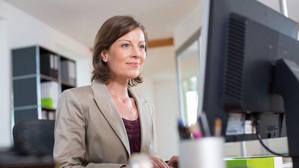 Mann und Frau vor einem Tablet-PC stehend im Büro