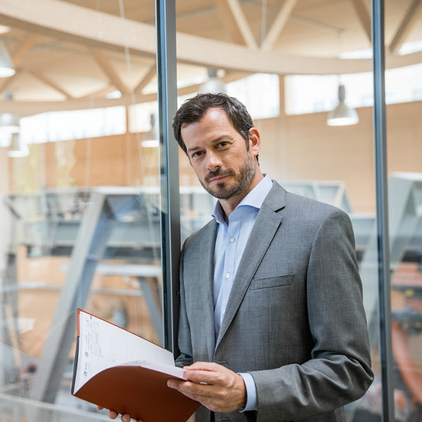 eine Person hält gebundene Dokumente in seinen Händen