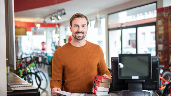 Steuerberater und sein Mandant stehen in der Lagerhalle