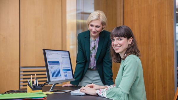 Zwei Männer und eine Frau sitzen im Büro vor dem Laptop