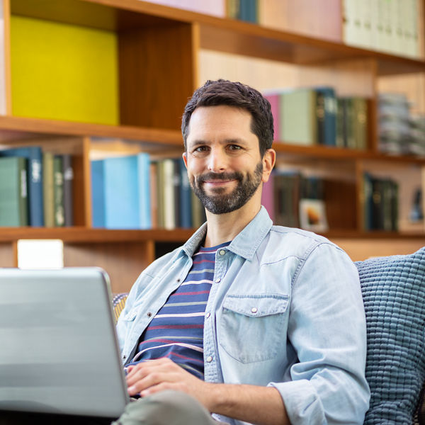 Ein Mann sitz im Büro mit dem Laptop