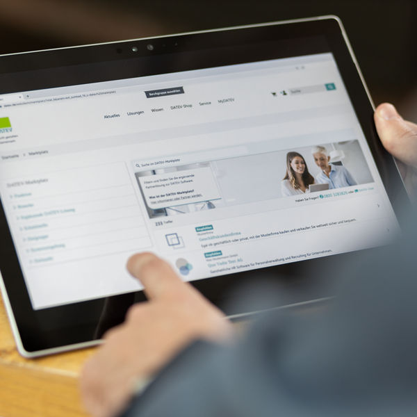 Tablet ist zu sehen mit Hände, die es bedient