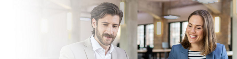 Zwei Personen vor dem Monitor im Büro