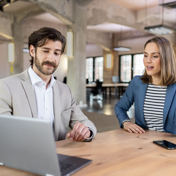 Steuerberater und Mandantin unterhalten sich.