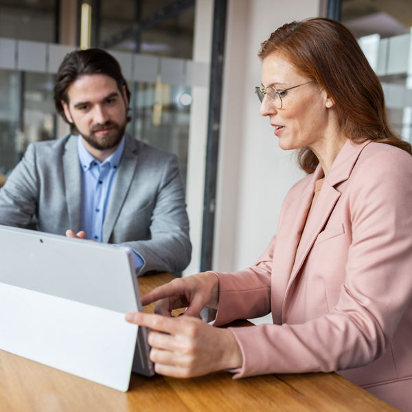 Mann und Frau vor dem Laptop sitzend im Büro