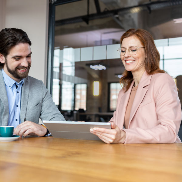 Frau und Mann im Büro vor dem Tablet-PC