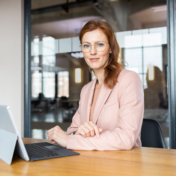 Frau am Schreibtisch vor dem Laptop