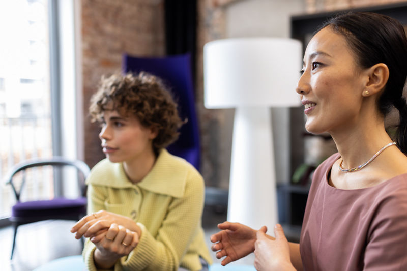 Zwei Personen lächelnd im Gespräch