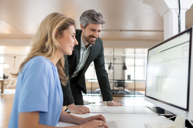 Rechtsanwalt und Rechtsanwaltsfachangestellte vor Computer