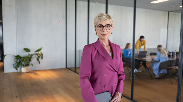 Eine Frau hält ein Tablet in der hand und bereitet sich auf ein Meeting vor.