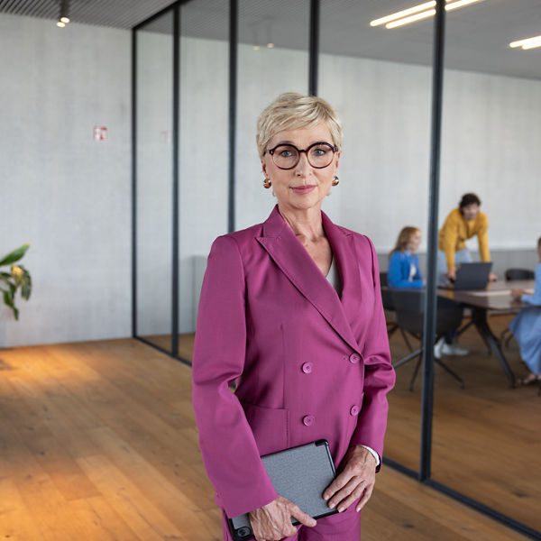Eine Frau hält ein Tablet in der hand und bereitet sich auf ein Meeting vor.