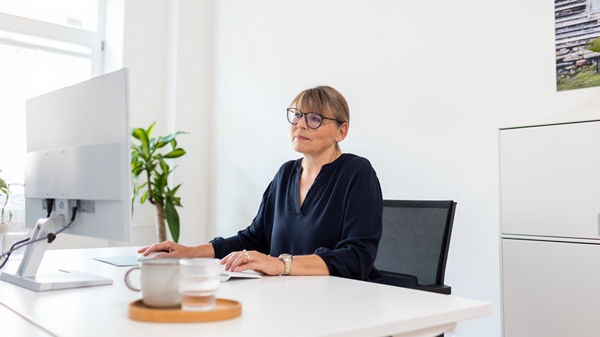 Frau sitzt vor einem Computer.