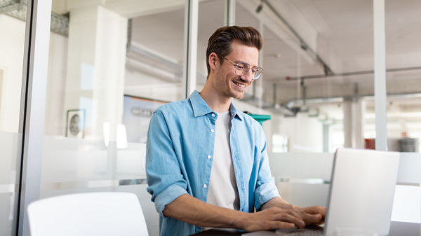 Ein Mann arbeitet an seinem Laptop. 