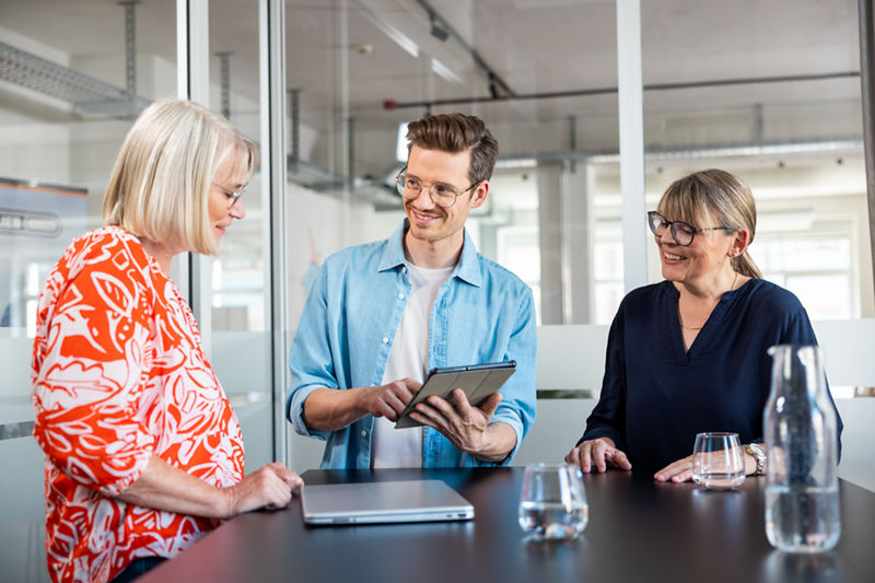 Drei Kollegen besprechen etwas im Büro. 