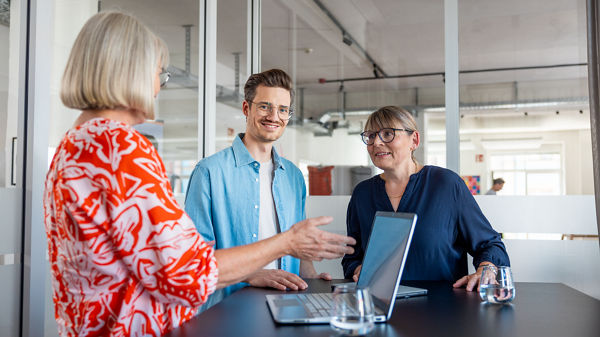 Drei Kollegen arbeiten gemeinsam im Büro. 