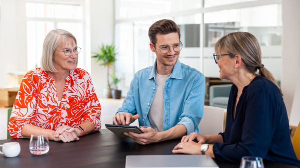 Drei Kollegen besprechen etwas gemeinsam im Büro. 