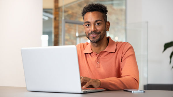 Ein Mann arbeitet an seinem Laptop. 