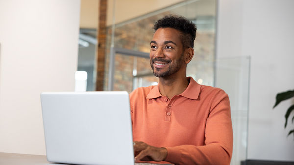 Ein Mann arbeitet an seinem Laptop. 
