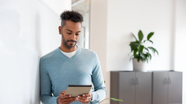 Ein Mann arbeitet an seinem Tablet. 