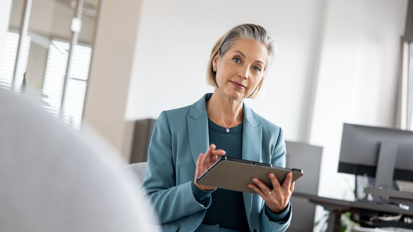 Frau hält ein Tablet in der Hand. 