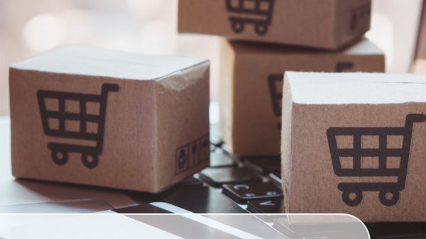 Buchcover mit Titel &#39;Umsatzsteuer im Online-Handel: Praxisbeispiele&#39; von Kerstin Gromadka , mit DATEV-Logo und Kartons mit Einkaufswagen-Symbol auf Laptop-Tastatur, veröffentlicht von DATEV.