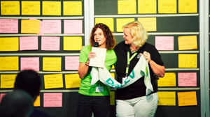 zwei Frauen stehen vor einer Leinwand mit Post-Its