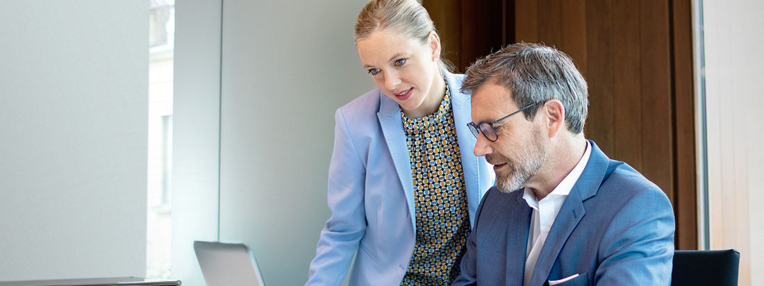 2 Menschen schauen in ein Laptop 