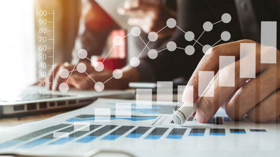 business documents on office table with smart phone and digital tablet and graph business with social network diagram and two colleagues discussing data working in the office
