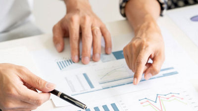 Hände zeigen auf eine ausgedruckte Statistik auf einem Tisch