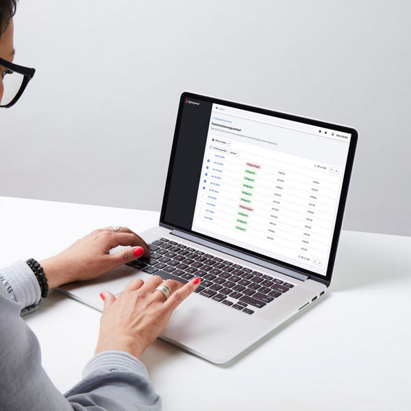 Eine Person arbeitet an einem Laptop mit der Softwareoberfläche von Lightspeed. Auf dem Bildschirm ist eine Tabelle mit Transaktionsdaten, Datumsangaben und farblich gekennzeichneten Statusanzeigen wie ‚Erfolgreich‘ und ‚Fehlgeschlagen‘ zu sehen.