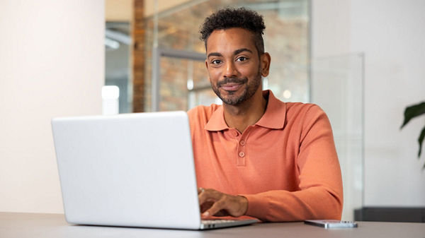 Ein Mann arbeitet an seinem Laptop. 